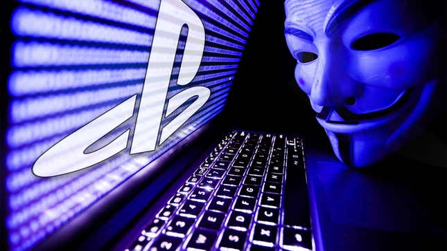 Guy Fawkes' mask leans over a laptop emblazoned with the PlayStation logo on the screen.